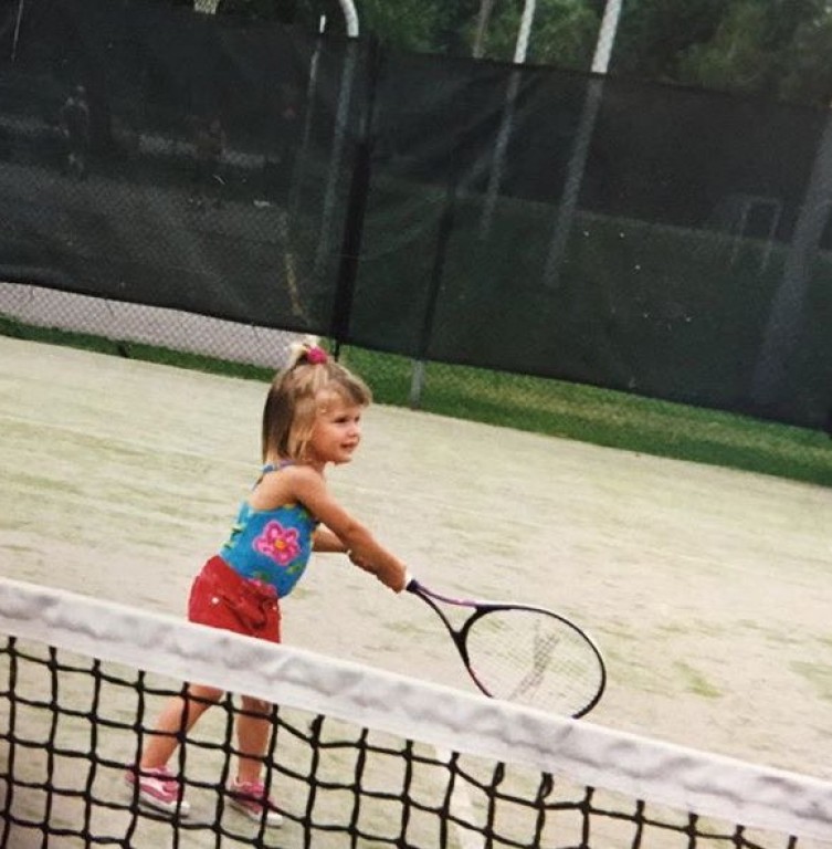 Eugenie Bouchard sur un terrain de Tennis à l'âge de 5 ans, elle tient sa raquette à deux mains.