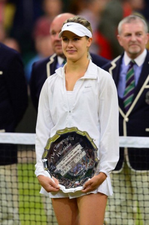 Eugenie Bouchard vêtue de blan se tient debout avec son trophée de finaliste au tournoi de Wimbledon.