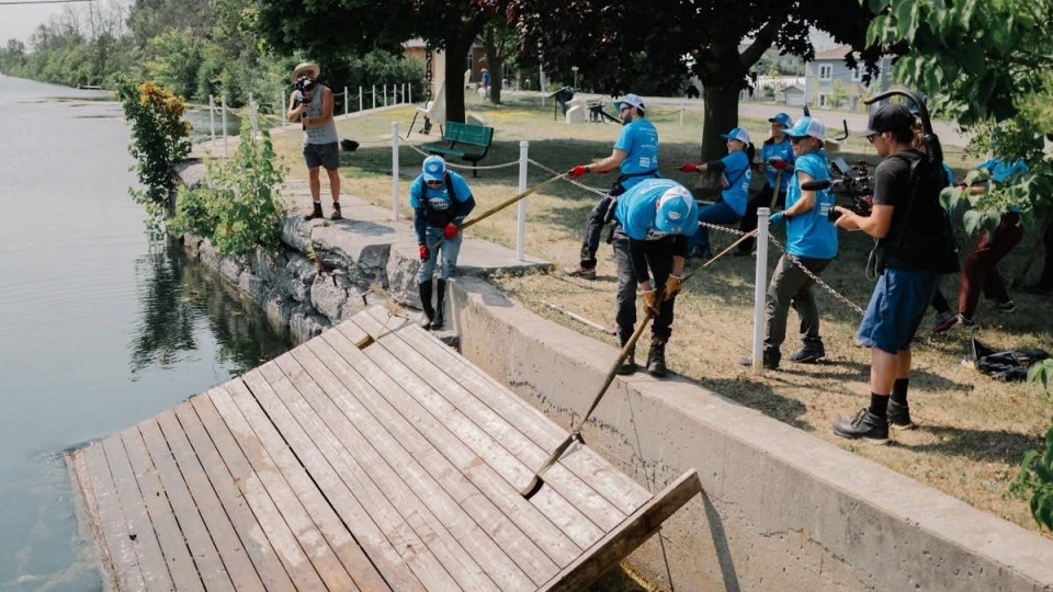 les jeunes tentent de sortir une grosse plateforme de bois de l'eau