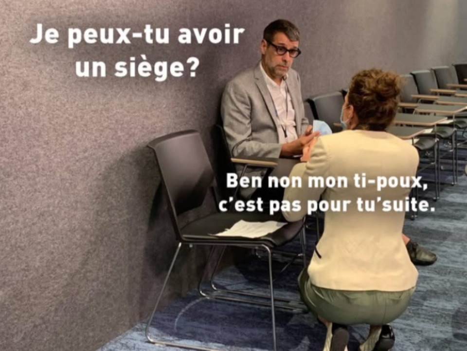 eric duhaime assis sur une chaise et une dame lui parle