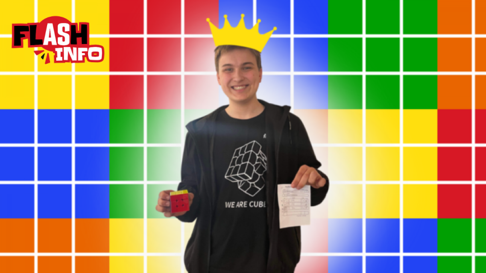 Eliott pose avec un cube Rubik et une feuille qui certifie son record.