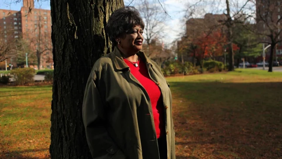 Claudette Colvin à 70 ans, accotée contre un arbre.