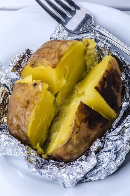 Une patate coupée en quatre dans du papier d'aluminium. 