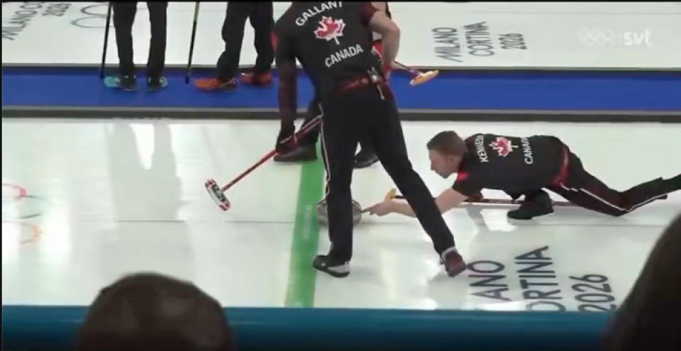 Le joueur de curling canadien Marc Kennedy durant un match des Jeux olympiques. Il touche encore légèrement du doigt la pierre qu'il vient de lancer. 