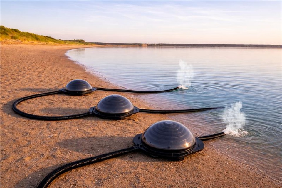 On voit trois chauffe-eau sur une plage. Ils sont directement reliés à l'eau du lac pour la réchauffer. 