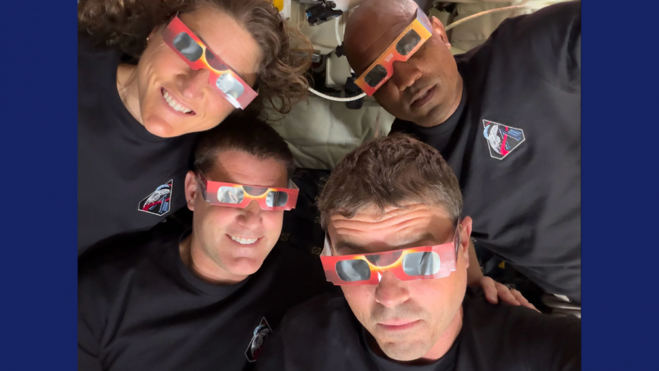 On voit les quatre astronautes qui portent des lunettes à éclipse. Ils sourient et ont pris la photo en mode selfie, en tenant eux-même la caméra. 