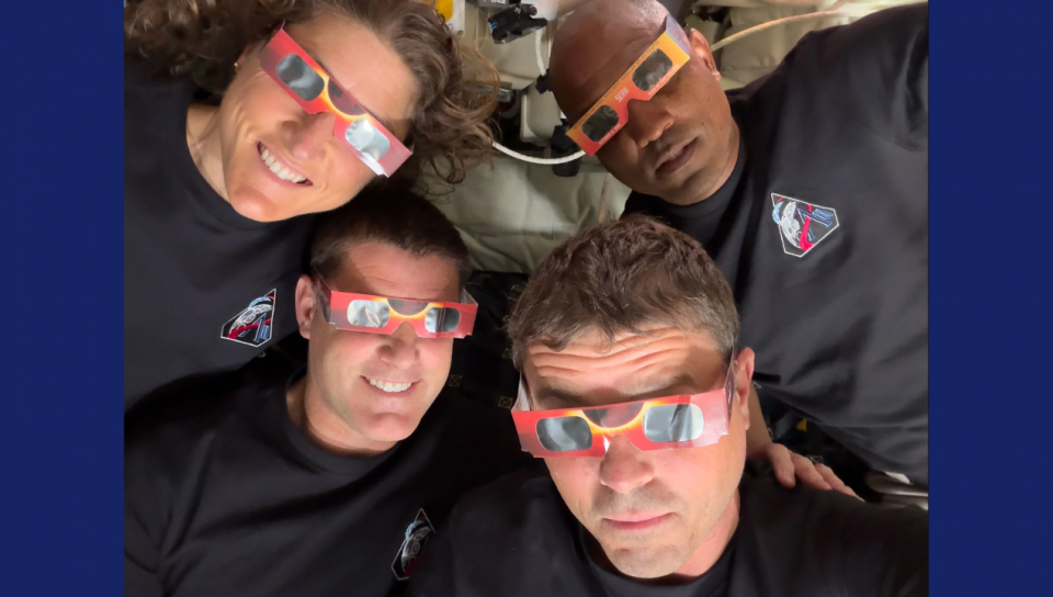 On voit les quatre astronautes qui portent des lunettes à éclipse. Ils sourient et ont pris la photo en mode selfie, en tenant eux-même la caméra. 