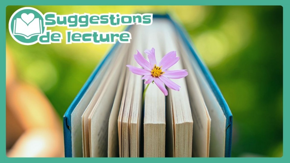 Un livre duquel une petite fleur rose dépasse.